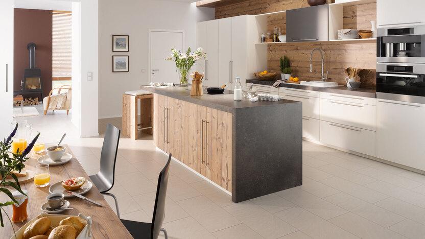 Impressionen einer Küche mit Esszimmer mit hellen Holzmöbeln und dunklen und weißen Fronten im Kontrast