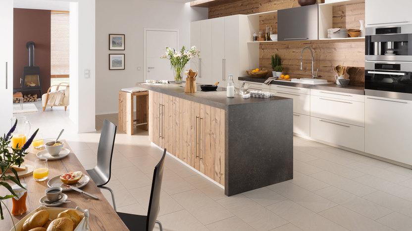 Impressionen einer Küche mit Esszimmer mit hellen Holzmöbeln und dunklen und weißen Fronten im Kontrast